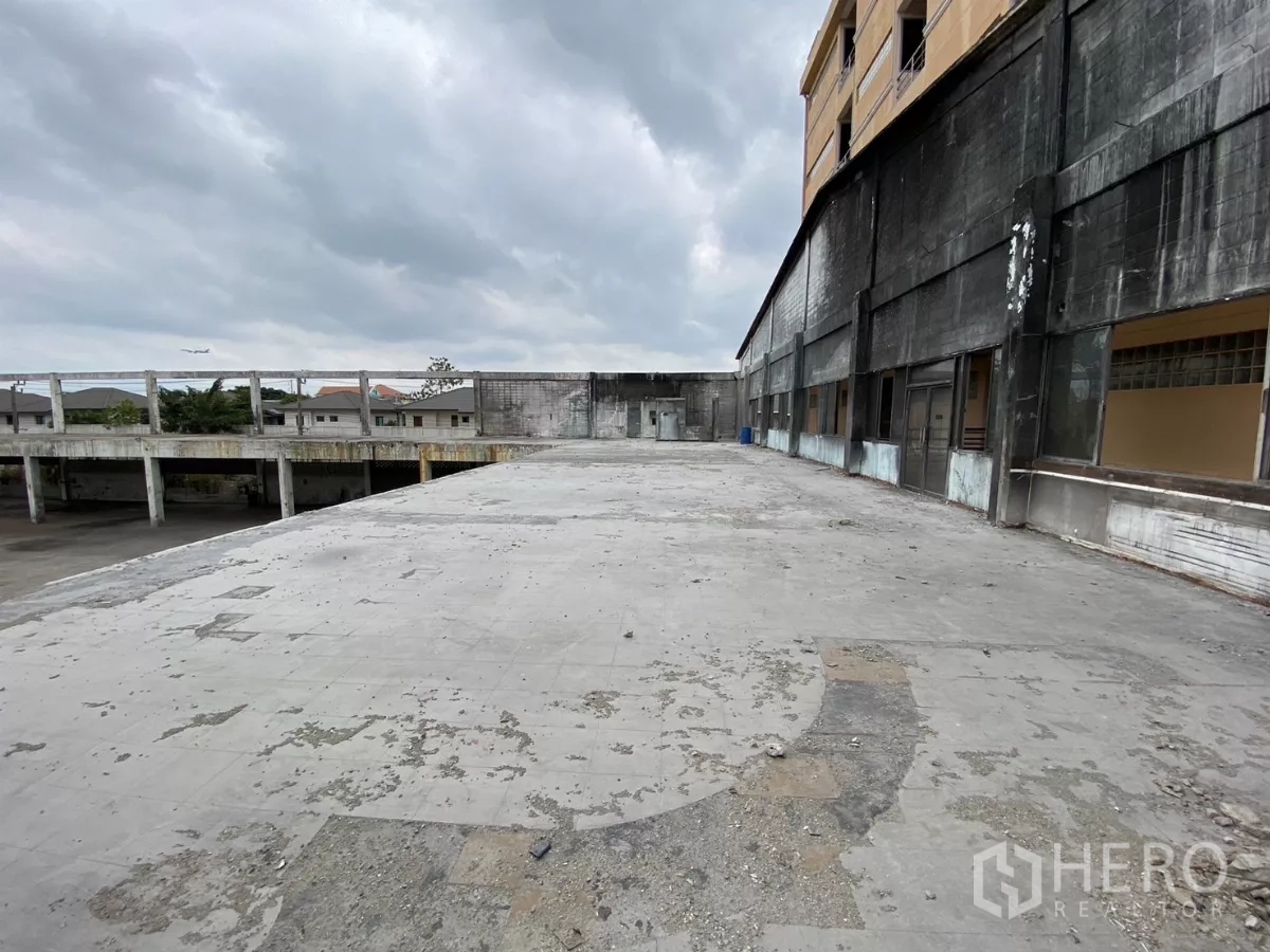 Factory for sale in Bang Phli, Samut Prakan - Weathered upper terrace beside office and factory facade.