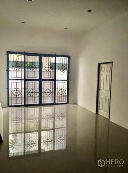 联排别墅 出租在Wang Thonglang, Bangkok - 采光充足的房间，亮面瓷砖地面，大窗配花纹防盗栏。