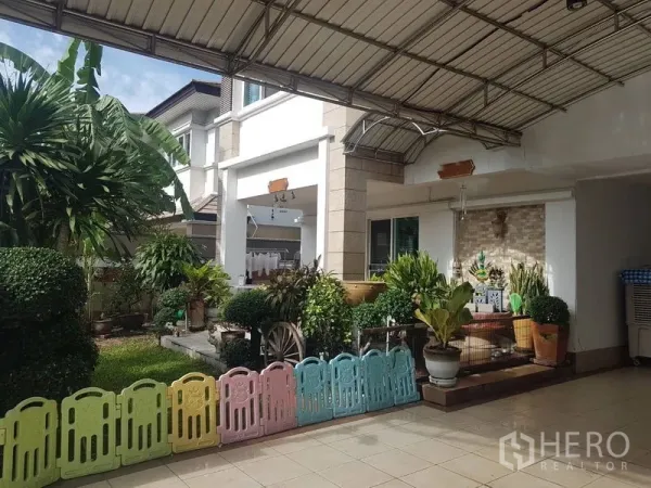 บ้าน ขายในSuan Luang, Bangkok - โรงจอดรถมีหลังคาและเฉลียงสวนของบ้านเดี่ยวสองชั้นในเขตสวนหลวง กรุงเทพฯ
