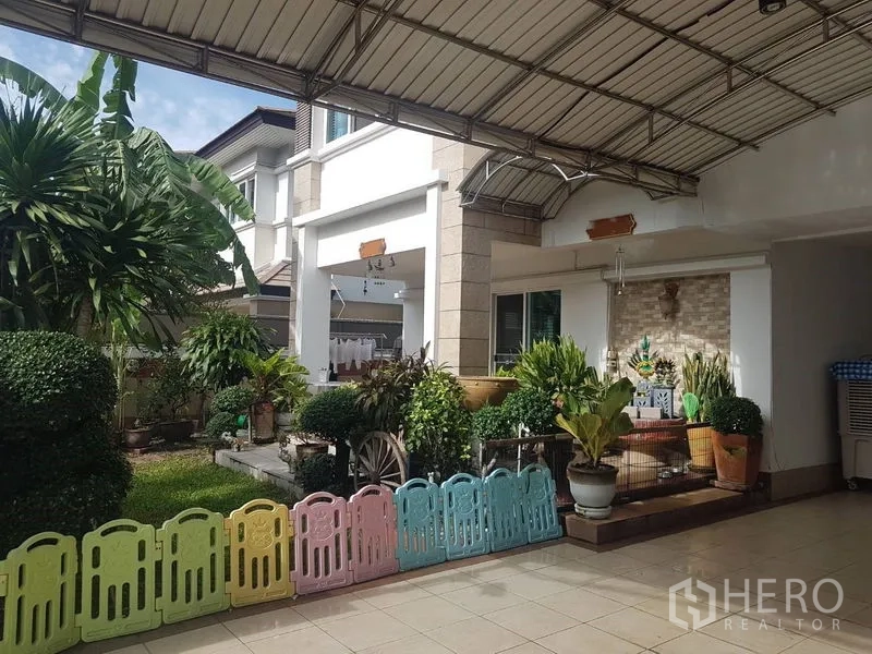 บ้าน ขายในSuan Luang, Bangkok - โรงจอดรถมีหลังคาและเฉลียงสวนของบ้านเดี่ยวสองชั้นในเขตสวนหลวง กรุงเทพฯ