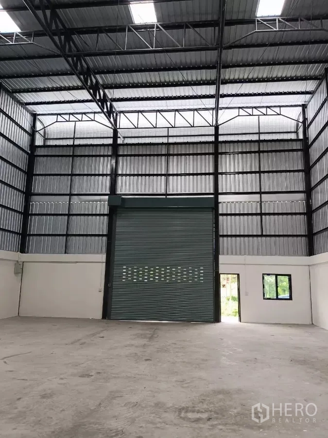 货栈 出租在Khlong Toei, Bangkok - 室内朝卷闸门视角，带侧门与窗户。