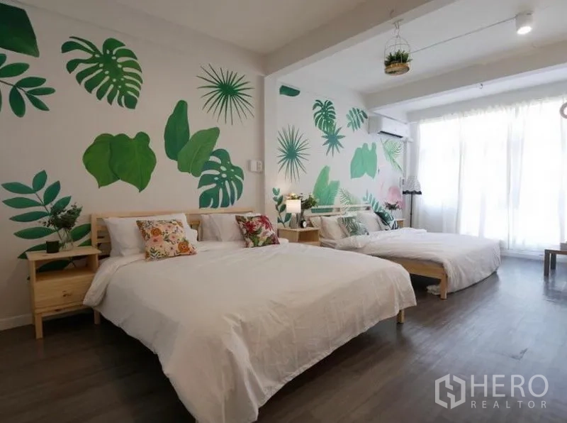 联排别墅 出租在Khlong Toei, Bangkok - 大卧室配两张双人床，热带叶子墙绘，木地板与落地窗。