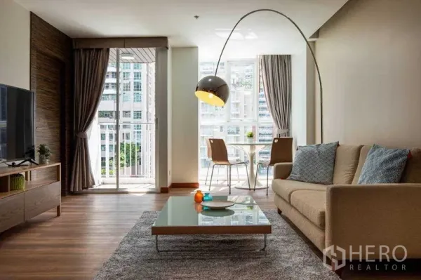 Condominium for rent in Pathum Wan, Bangkok - Bright living and dining area with sofa, TV console, balcony and city view