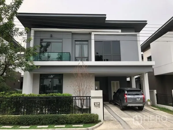 บ้าน ให้เช่าในSaphan Sung, Bangkok - บ้านเดี่ยวสองชั้นสไตล์โมเดิร์น มีที่จอดรถ ทางเข้ารถ และระเบียงกระจกพร้อมรั้วสวนหน้า