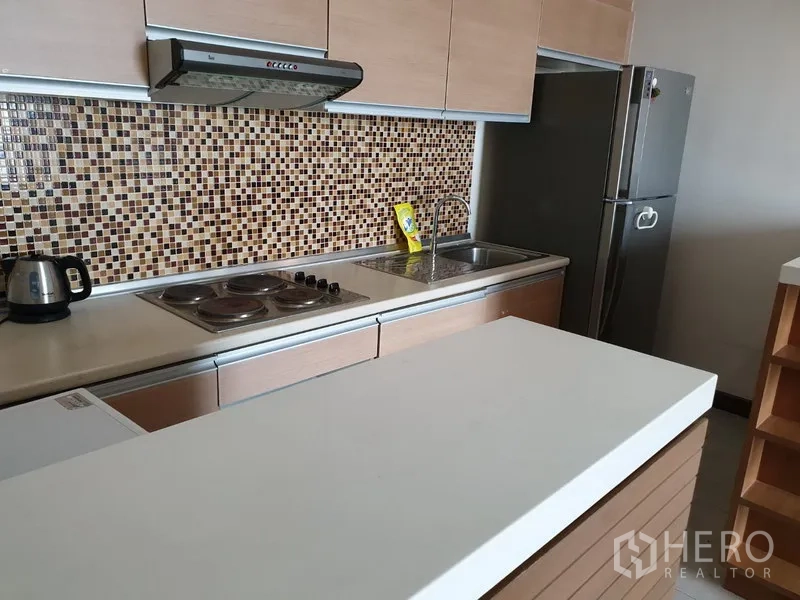 公寓 出租在Watthana, Bangkok - 现代一字型厨房，马赛克墙面，电炉、抽油烟机、水槽与不锈钢冰箱。