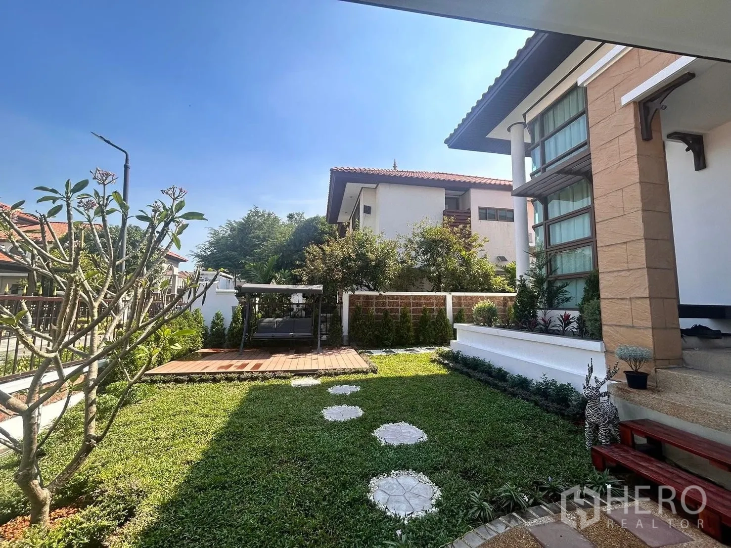 Detached House for rent in Lat Krabang, Bangkok - Front lawn with swing deck and modern facade of a detached house.