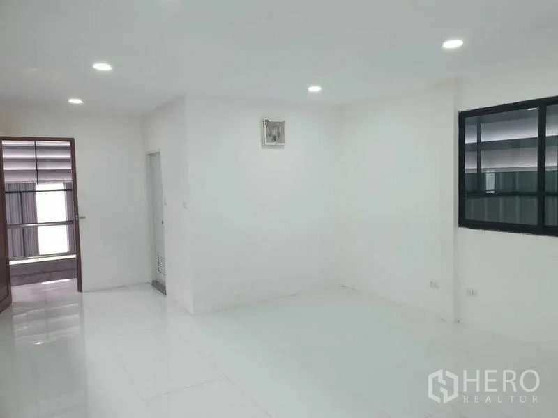Warehouse for rent in Prawet, Bangkok - Bright ground-floor office room with white tiles and recessed lights.