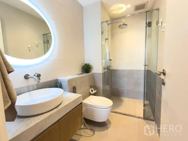 Apartment for rent - Modern bathroom with glass rain shower, backlit mirror and floating vanity.