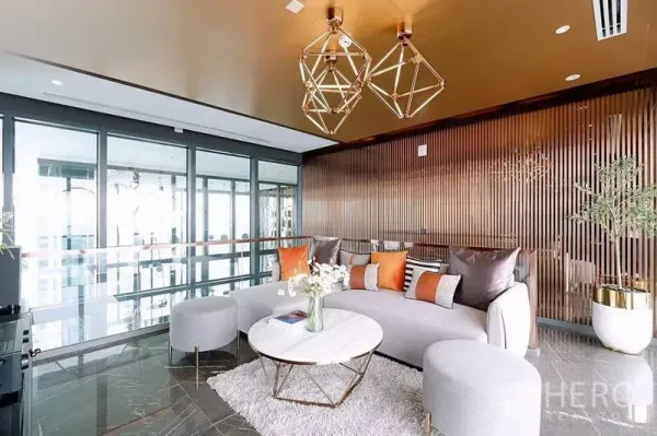 Condominium for rent in Watthana, Bangkok - Stylish lounge with geometric gold pendant lights, curved sofa and floor‑to‑ceiling windows.