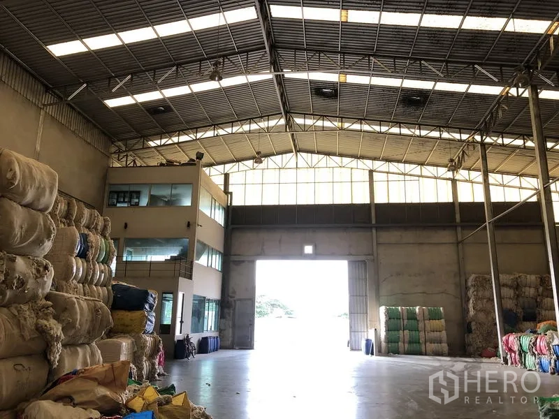 โรงงาน ให้เช่าในBang Bua Thong, Nonthaburi - ทางเข้าโกดังพร้อมประตูโรลเลอร์สูง และอาคารสำนักงานกระจกติดด้านข้าง