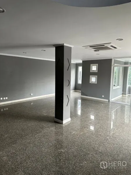 Townhouse for rent in Bang Kapi, Bangkok - Large open-plan living area with polished stone floors and a central pillar.