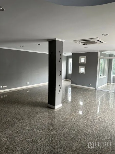 Townhouse for rent in Bang Kapi, Bangkok - Large open-plan living area with polished stone floors and a central pillar.