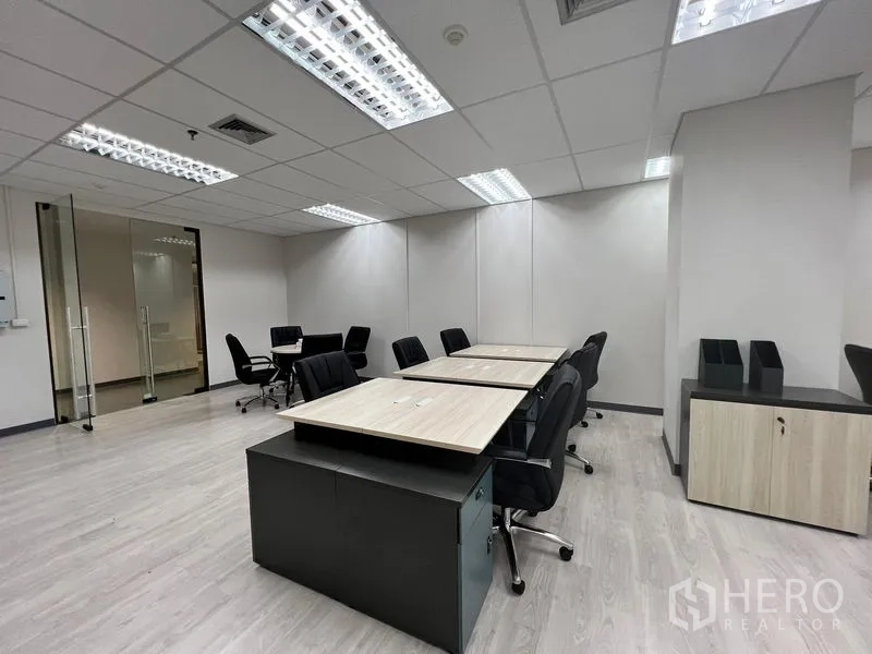 Office Space for rent in Sathon, Bangkok - Shared desk row with rolling pedestal drawers, neutral walls and glass entry creating a clean modern office.