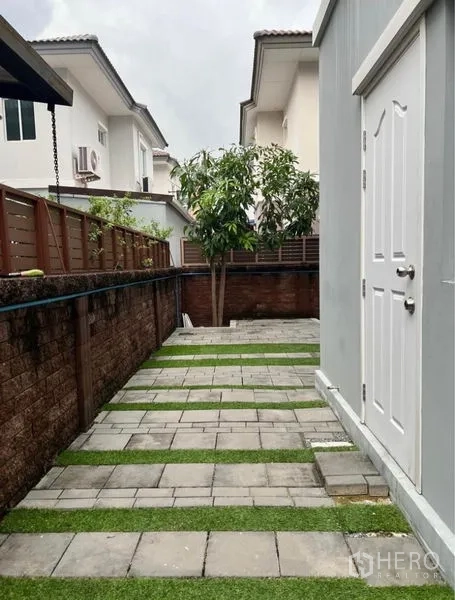 บ้าน ให้เช่าในSuan Luang, Bangkok - ลานด้านข้างปูกระเบื้องสลับหญ้า และห้องเก็บของภายนอก