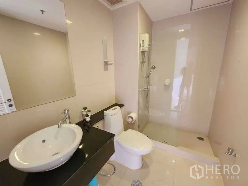 Condominium for rent in Khlong Toei, Bangkok - Second bathroom with walk-in shower, floating vanity and white sanitary ware.