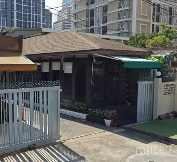Retail Space for rent in Watthana, Bangkok - Gated retail unit with pitched roof and awning, set amid a high‑rise neighborhood.