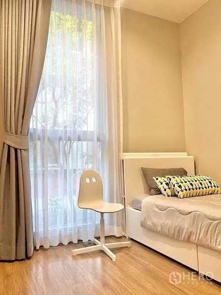 คอนโด ขายในWatthana, Bangkok - ห้องนอนรองอบอุ่น เตียงเดี่ยวและหน้าต่างสูงพร้อมม่านโปร่ง