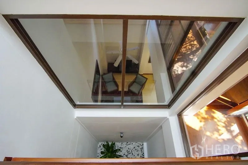 ทาวน์เฮาส์ ให้เช่าในWatthana, Bangkok - โถงกลางบ้านแบบแอทเรียม มองลงสู่ห้องนั่งเล่นผ่านกระจก