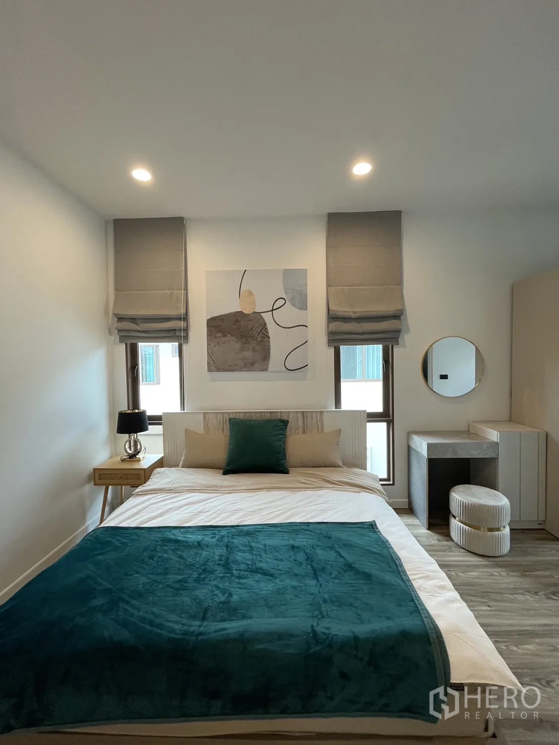 Detached House for rent in Bang Kapi, Bangkok - Guest bedroom with teal throw blanket, side tables, and artwork.