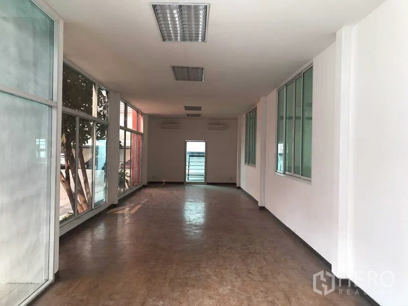 Factory for rent in Samut Prakan - Bright corridor‑style office area with floor‑to‑ceiling windows on both sides.