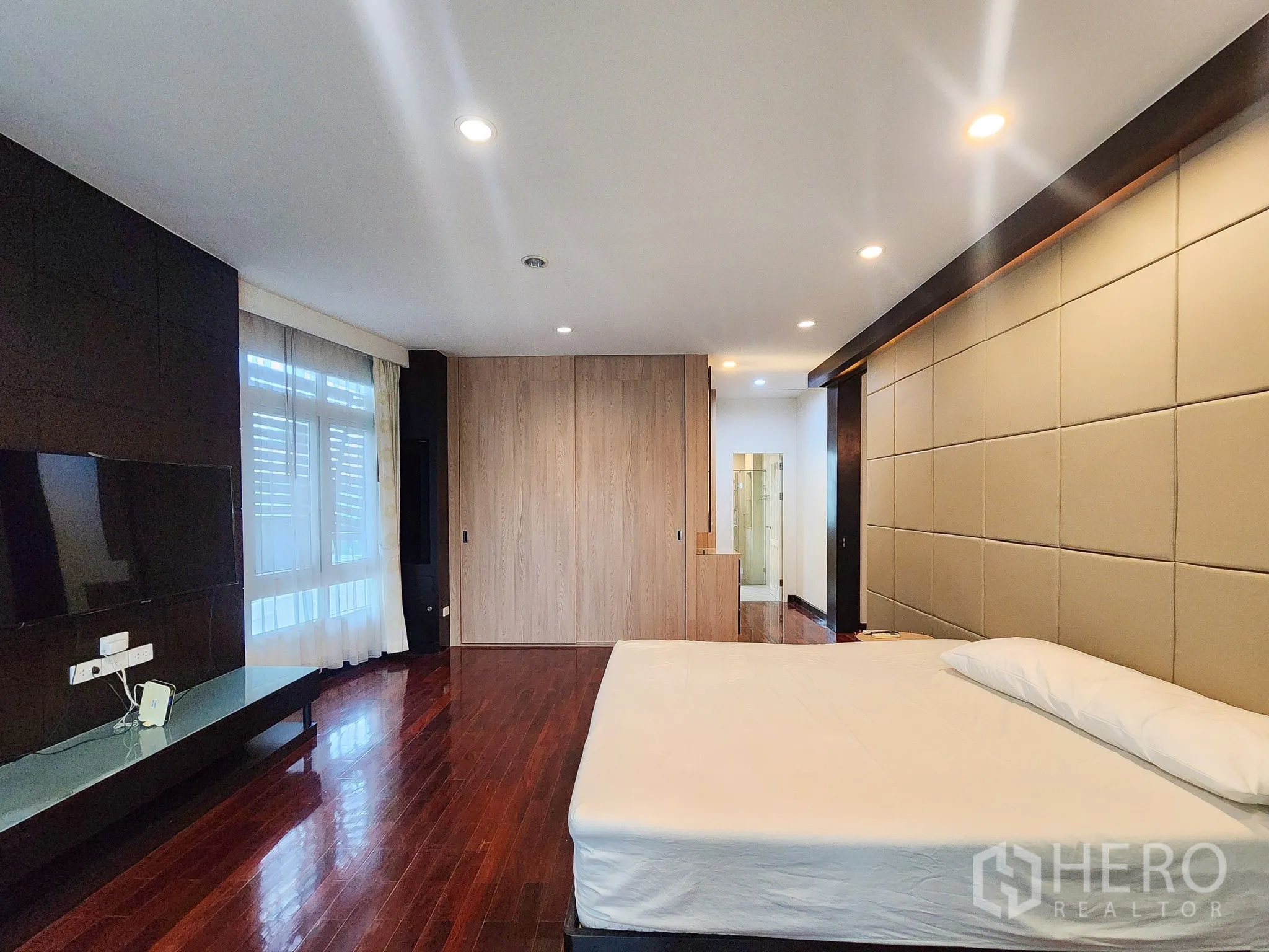 Detached House for rent in Bang Kapi, Bangkok - Master bedroom showing TV wall opposite and floor-to-ceiling windows.