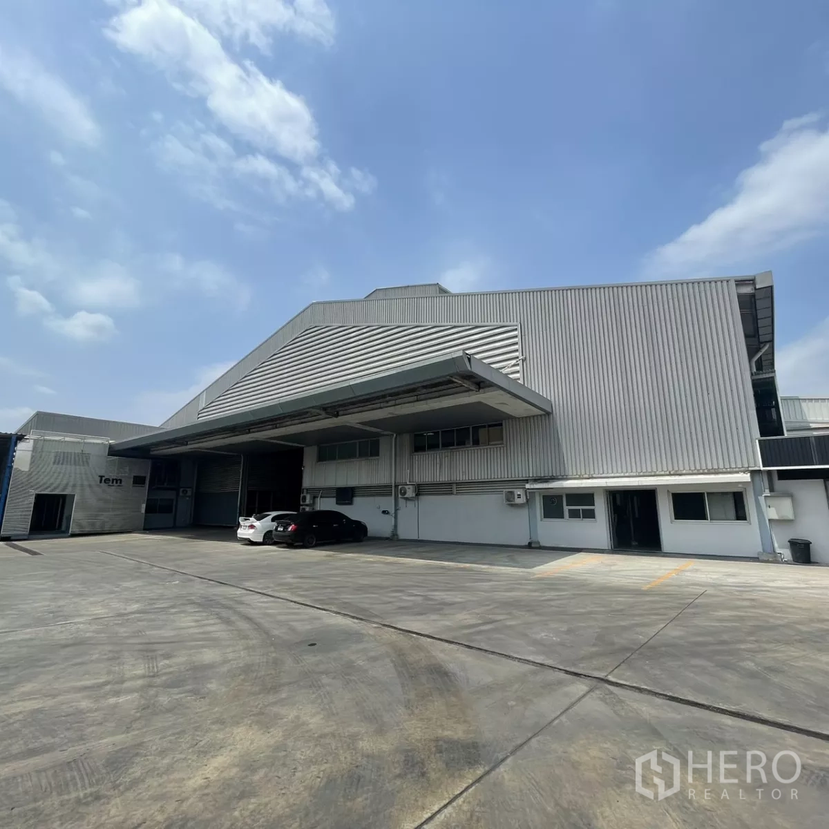 Factory for rent in Bang Phli, Samut Prakan - Modern metal-clad warehouse exterior with wide loading canopy and large concrete yard in Bang Phli.