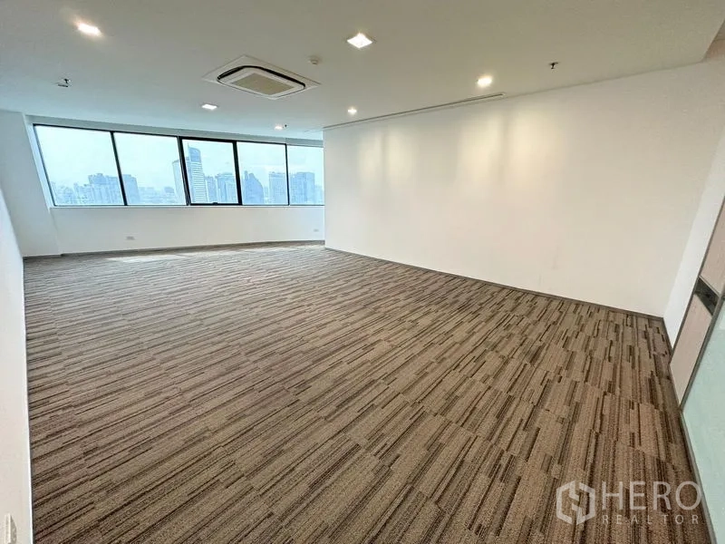 办公空间 出租在Watthana, Bangkok - 宽敞办公区，嵌灯照明与大幅城市景观窗。