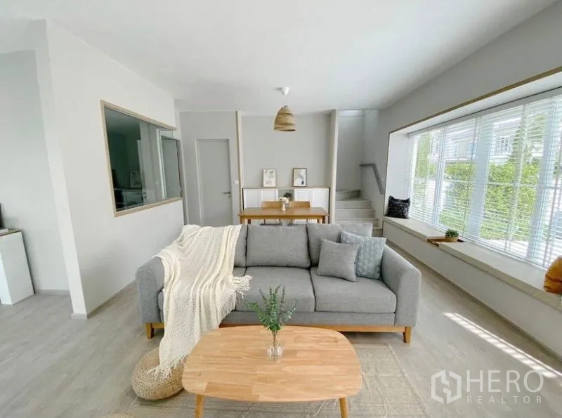 Detached House for rent in Prawet, Bangkok - Cozy living room with oversized picture window and stairs to the upper floor.
