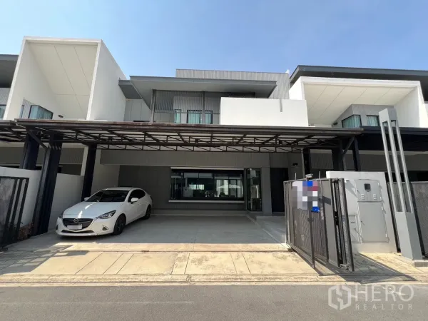 独立式住宅 出租在Bang Phli, Samut Prakan - 现代两层独立屋外观，带宽敞有顶车棚与滑动大门。