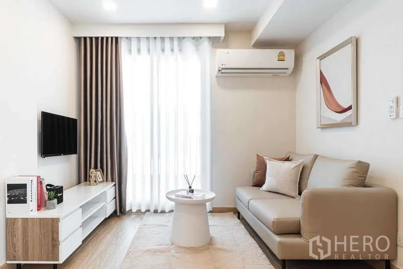 Condominium for rent - Living room with TV console, air conditioner and sheer curtains to the balcony.