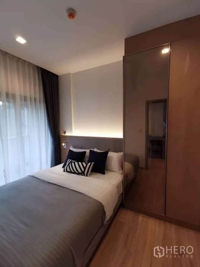 公寓 出租在Watthana, Bangkok - 温馨卧室，双人床、镜面衣柜与纱帘。