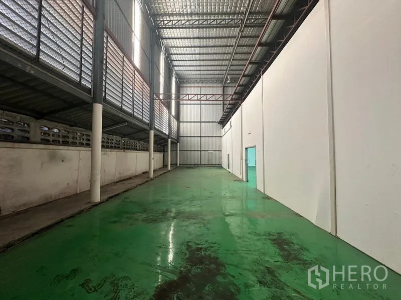 Warehouse for rent in Suan Luang, Bangkok - Covered loading area with ventilated siding and a high roof.