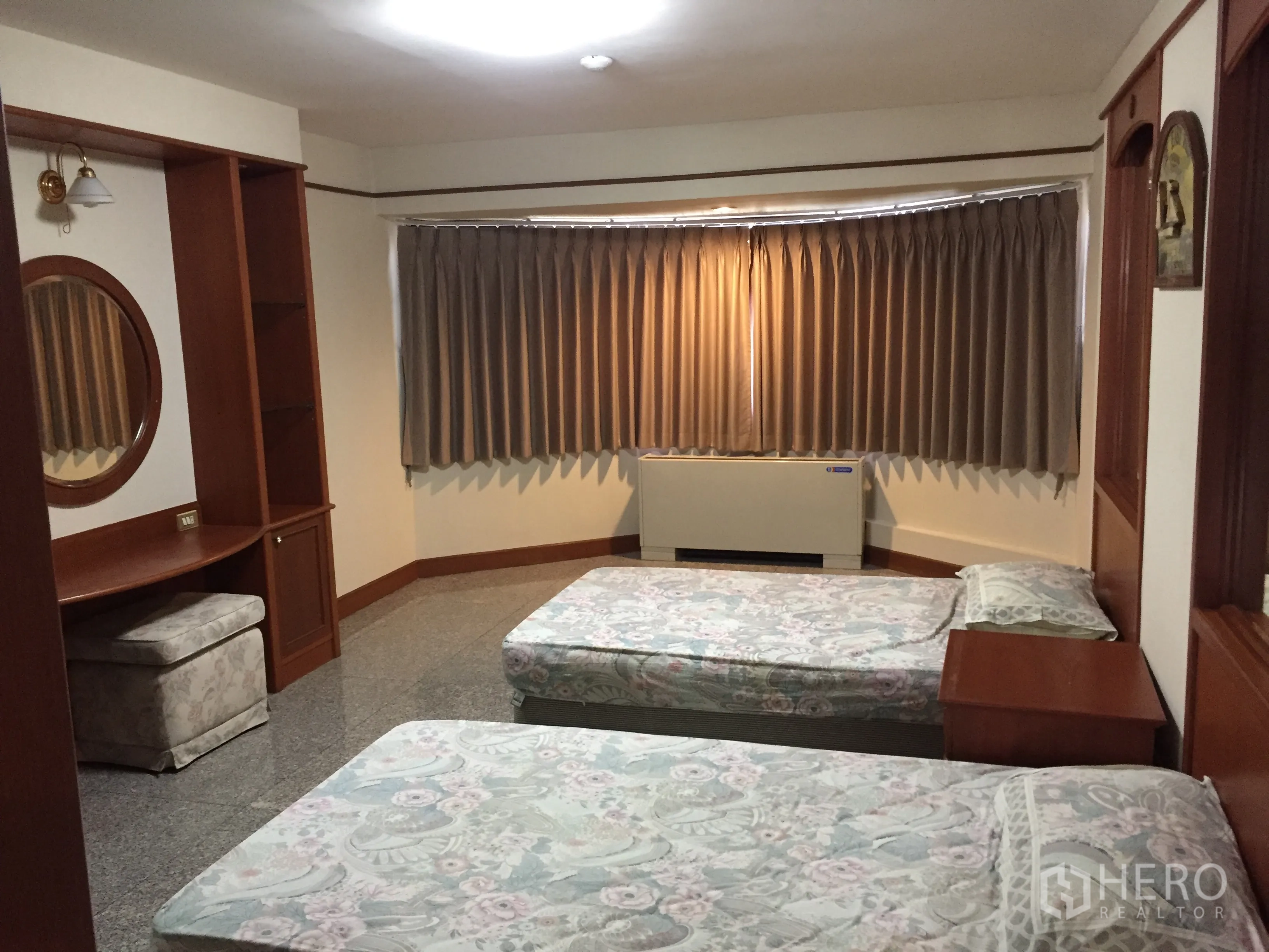Condominium for rent in Watthana, Bangkok - Twin bedroom with two single beds, bay window with heavy curtains, built-in desk and shelving unit.