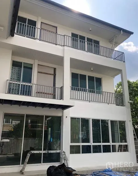 Detached House for rent - Three-storey white detached house with large windows and balconies near BTS Wutthakat in Bangkok.