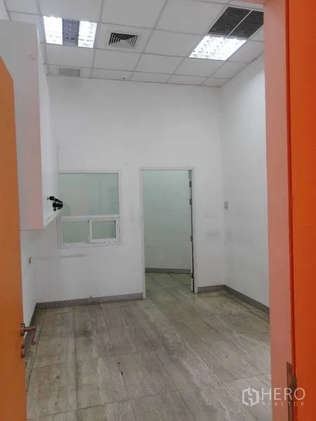 Office Space for rent in Pathum Wan, Bangkok - Compact back room with white walls, drop ceiling, and tiled floor suitable for storage or admin use.