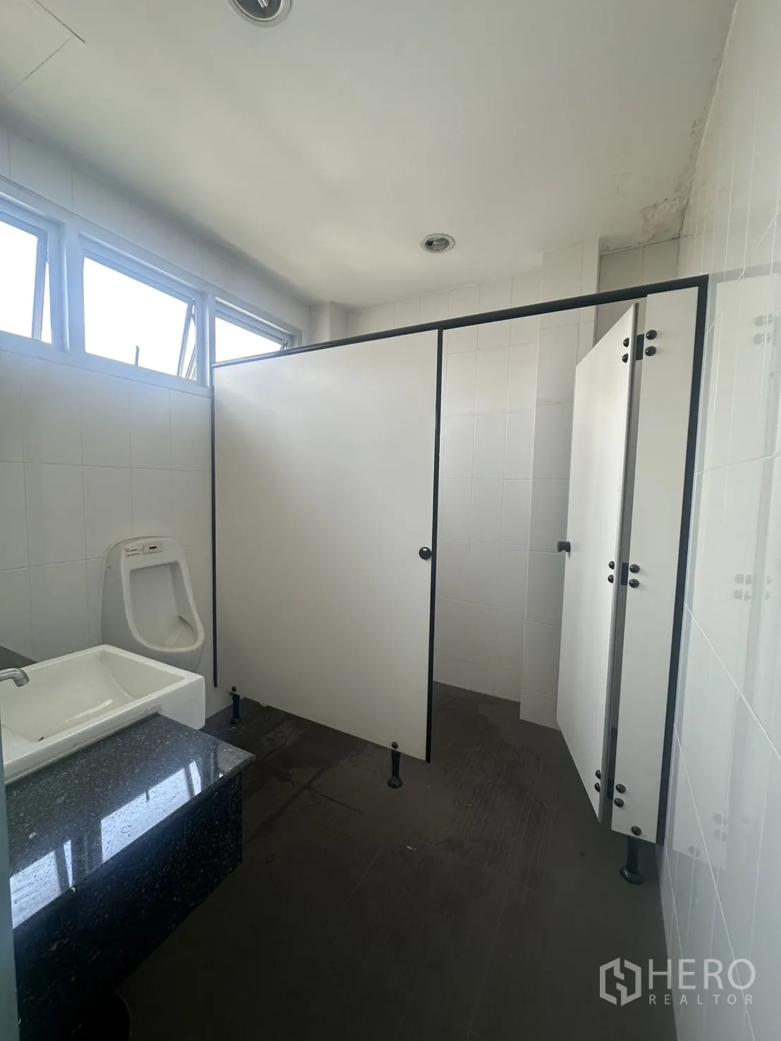 Retail Space for rent in Watthana, Bangkok - Restroom with partitions, urinal, sink and tiled walls, part of separate male and female facilities.