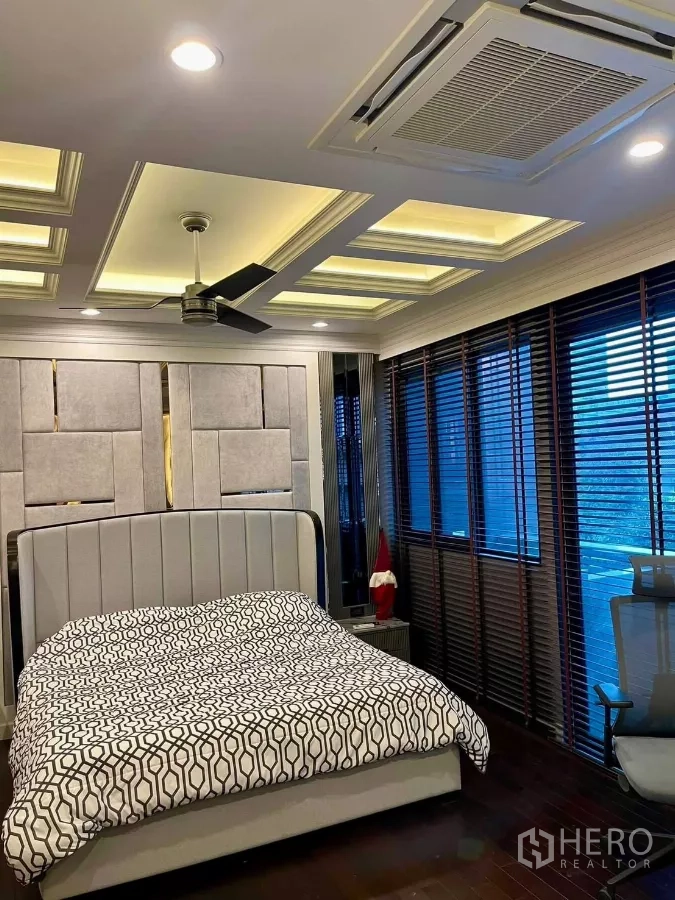 联排别墅 出租在Chatuchak, Bangkok - 卧室一角，吊顶嵌入空调、宽窗与吊扇。