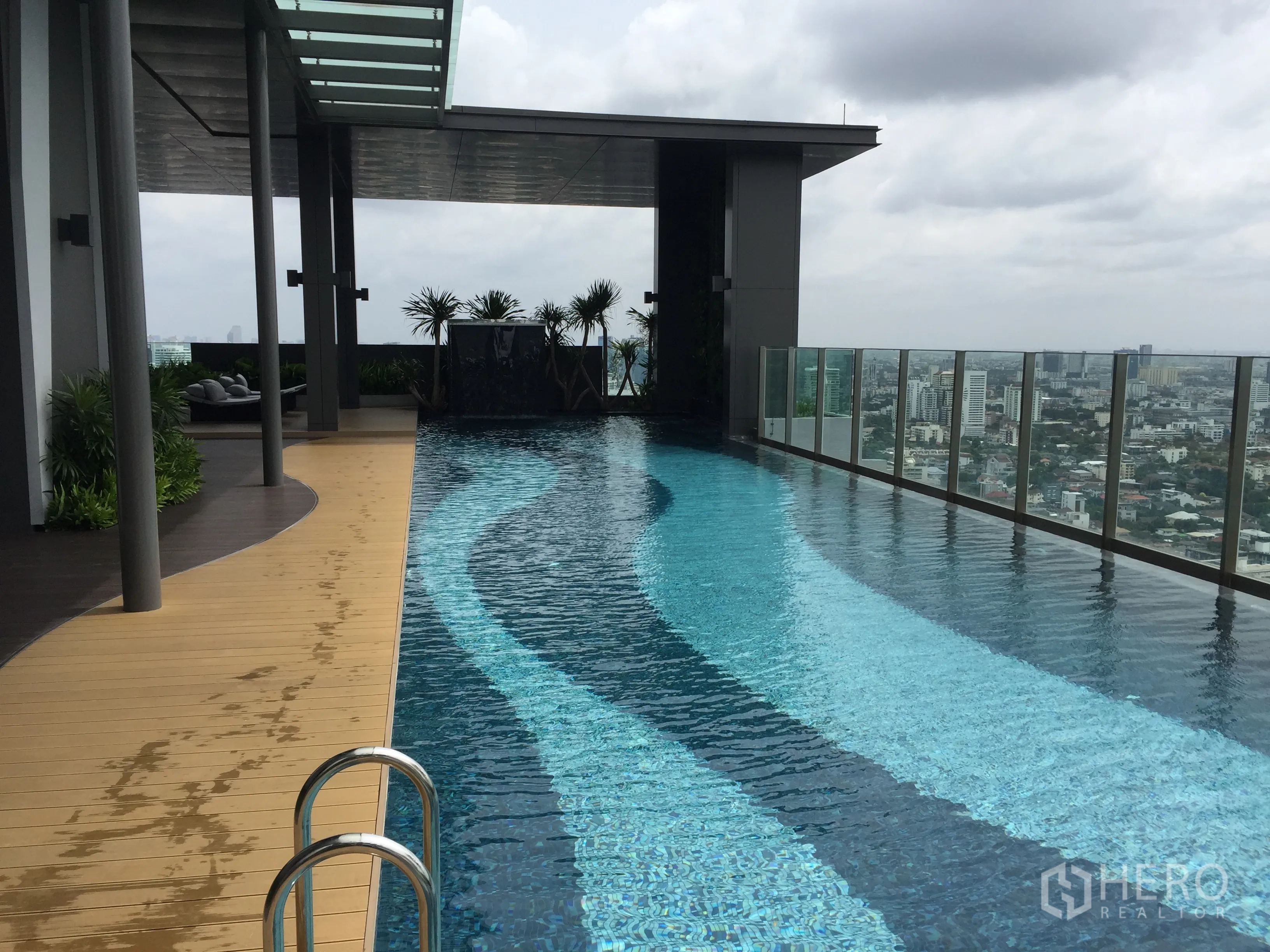 Condominium for rent in Khlong Toei, Bangkok - Rooftop infinity swimming pool with glass railing and panoramic Bangkok skyline views.
