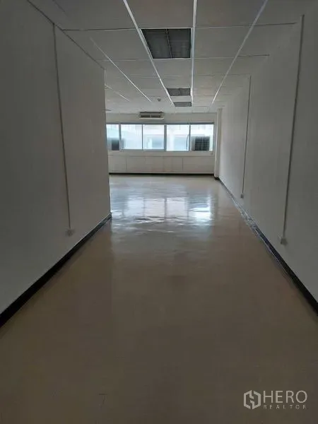 Office Space for rent in Pathum Wan, Bangkok - Long open-plan office corridor with polished floors, white walls, and windows at the far end.