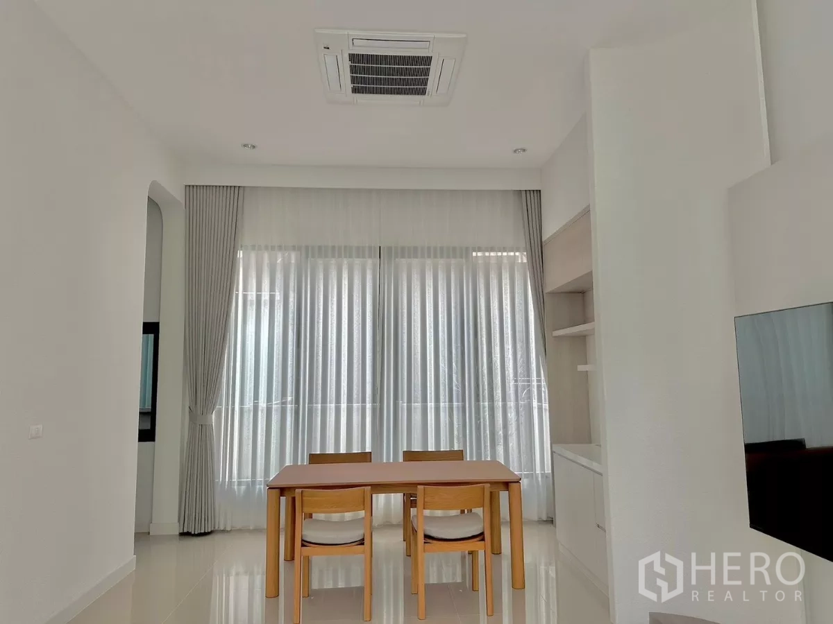 独立式住宅 出租或出售在Prawet, Bangkok - 餐区摆放四人木桌，内置柜与吊顶嵌入式空调。