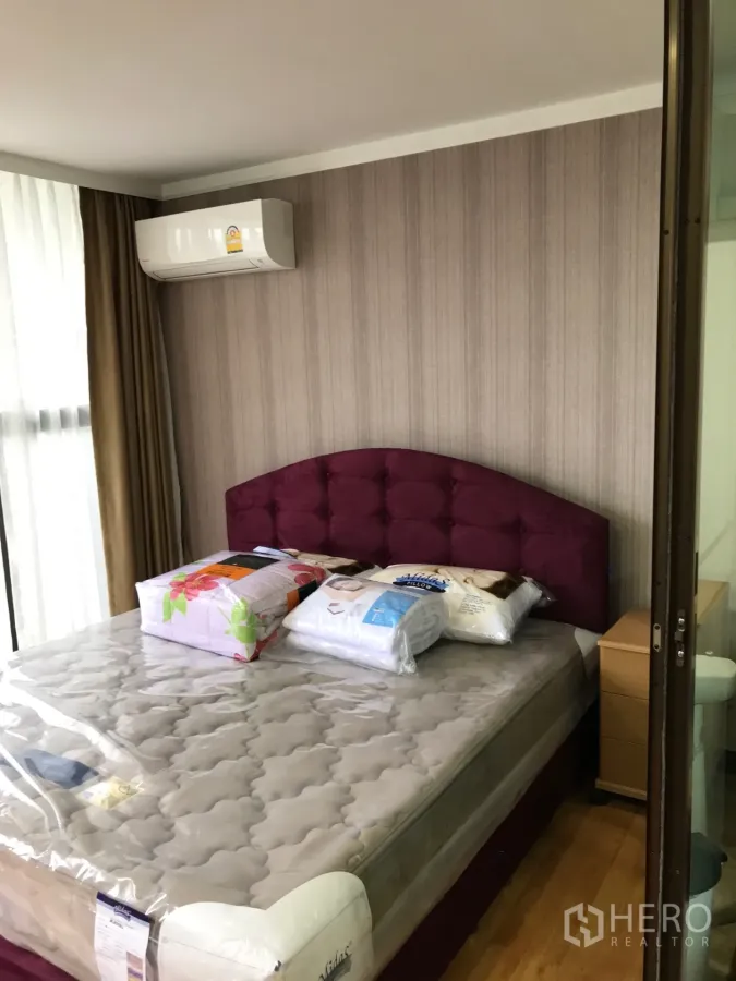 公寓 出租或出售在Watthana, Bangkok - 明亮卧室，酒红色软包床头、空调与落地窗帘