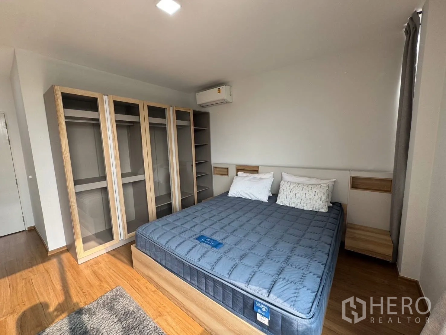 联排别墅 for rent in Bang Phli, Samut Prakan - 卧室展示整墙玻璃门衣柜与一张大床。