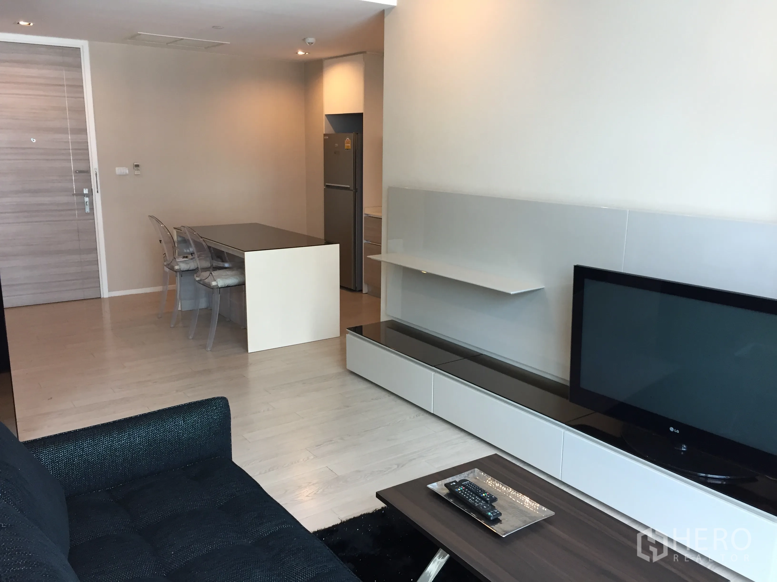 公寓 出租在Watthana, Bangkok - 开放式客餐厅，沙发、电视柜与浅色木地板。