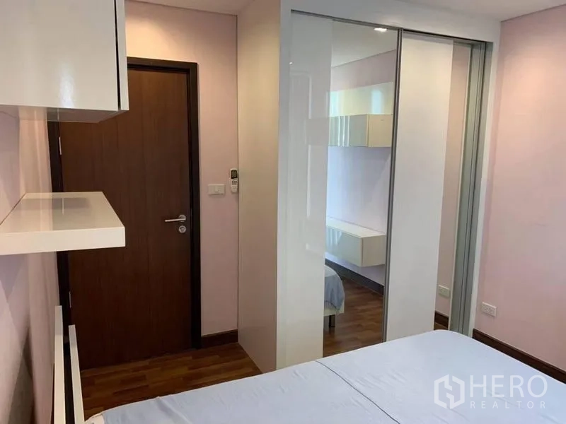 公寓 出租在Watthana, Bangkok - 次卧另一角度，推拉镜面衣柜与壁挂层板。