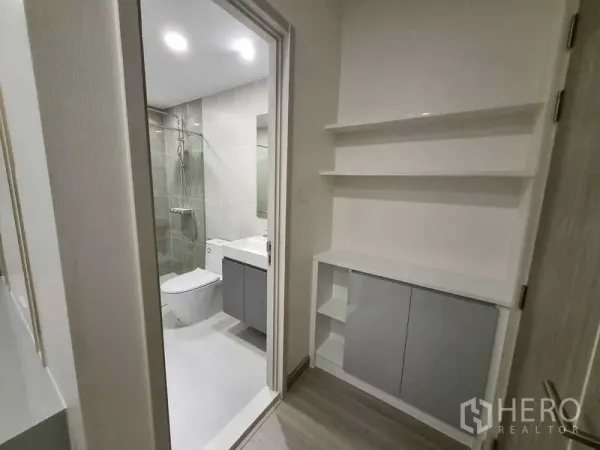 Condominium for rent - Hallway with open shelving leading into a tiled bathroom.