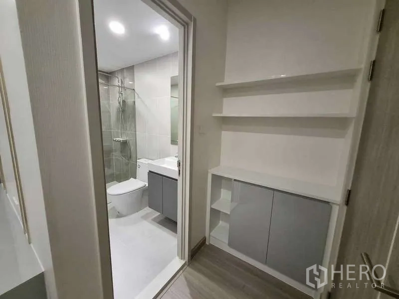 Condominium for rent - Hallway with open shelving leading into a tiled bathroom.