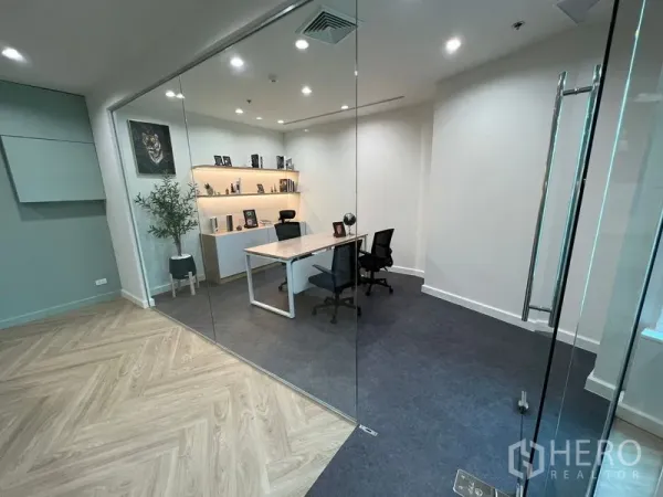Office Space for rent - Glass-walled executive office with desk, shelving and carpeted floor.