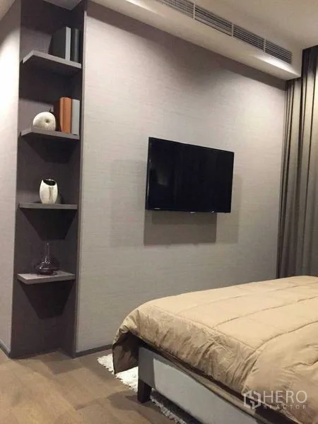 Condominium for rent in Bang Rak, Bangkok - Bedroom wall with mounted flat-screen TV and decorative corner shelves.