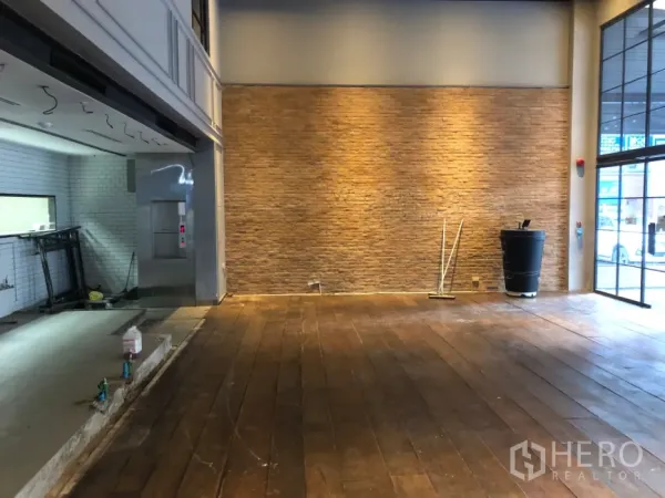 零售空间 出租在Khlong Toei, Bangkok - 开放式营业区，砖纹特色墙、暖光照明和木地板