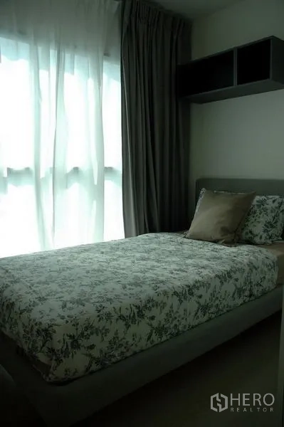 Condominium for sale in Khlong Toei, Bangkok - Cozy second bedroom with single bed by a bright window and dark curtains.